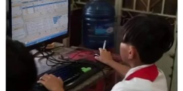 Child using an old computer, humorously risking a virus.
