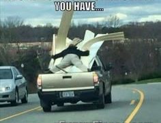 Guy holding lumber in a truck with no straps, showing an epic fail.