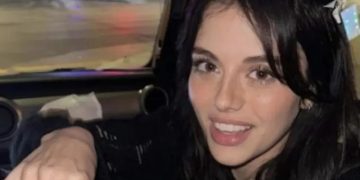 Woman reaching for food with a cheeky expression in car