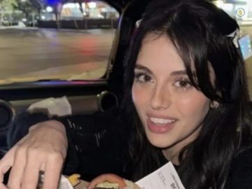 Woman reaching for food with a cheeky expression in car