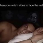 Man in bed wide awake facing wall with creepy shadows.