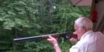 Grandpa veteran holding a rifle during a hide and seek game.