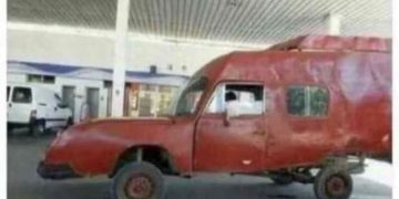 Wacky red car resembling a child’s drawing at a gas station.