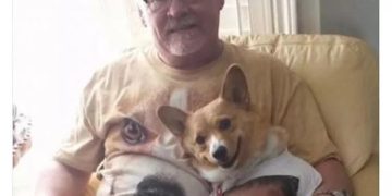 Man and dog wearing matching T-shirts with each other's faces.