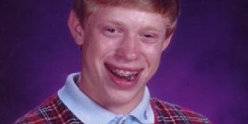 Teen in school photo with awkward smile and sweater vest
