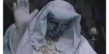 Statue raising hand like blessing a car letting you cross