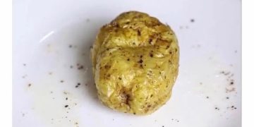 Potato on plate humorously representing waking up with alarm.