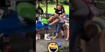 Outdoor party scene with a woman at a picnic table reacting as a green object flies toward her during a fail compilation.