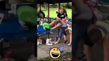 Outdoor party scene with a woman at a picnic table reacting as a green object flies toward her during a fail compilation.