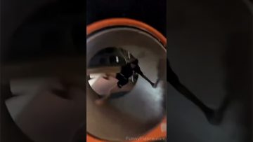 A person tumbles inside a playground spinning tube during a funny park fail.