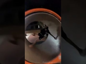 A person tumbles inside a playground spinning tube during a funny park fail.