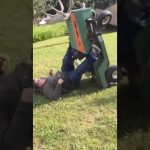 Man loses his balance while trying to cross a narrow ditch and falls into the water.