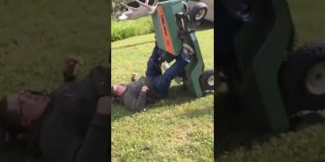 Man loses his balance while trying to cross a narrow ditch and falls into the water.