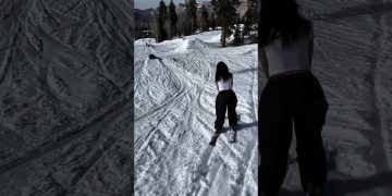 A skier loses balance while sliding a green rail during a snowy wipeout in a funny fails compilation.