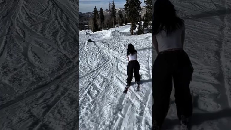 A skier loses balance while sliding a green rail during a snowy wipeout in a funny fails compilation.